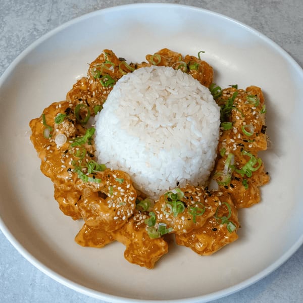 SanSai Japanese Grill's spicy chicken with white rice, green onions, and sesame seeds.